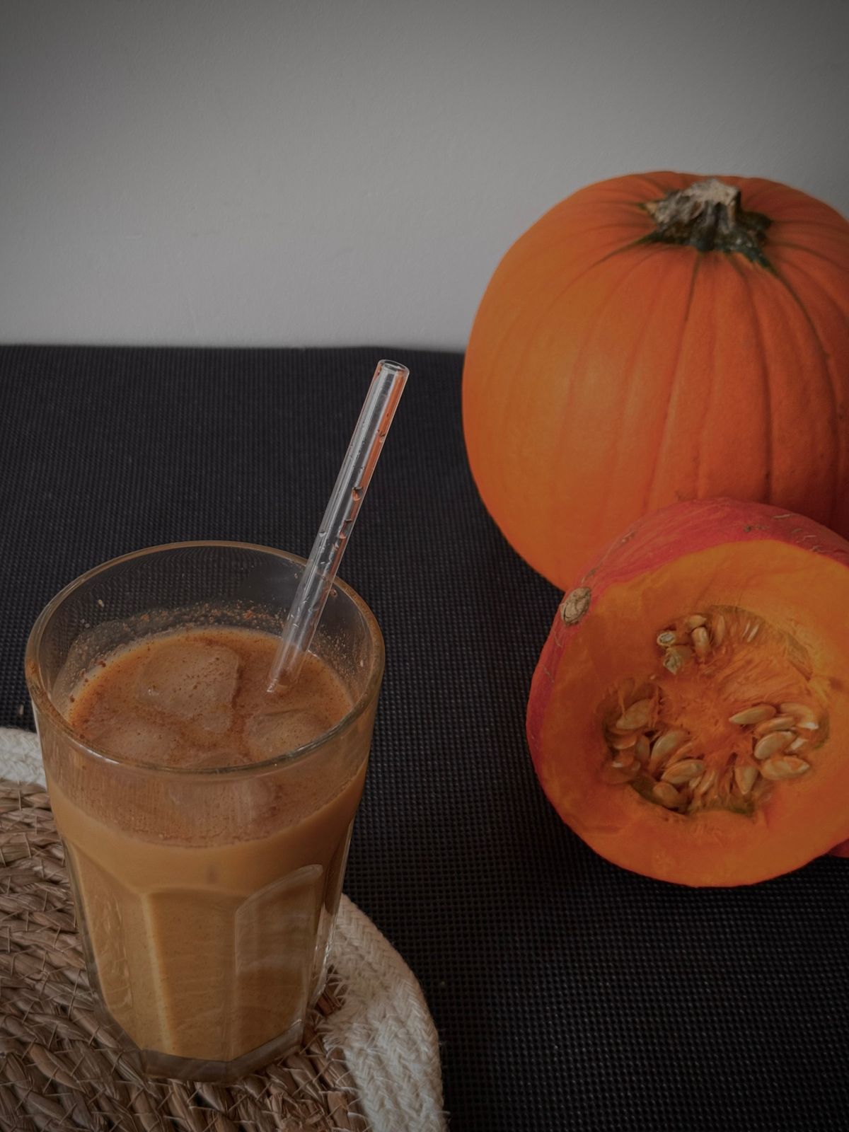 A pumpkin-themed beverage beside fresh pumpkins; illustrative stock photograph