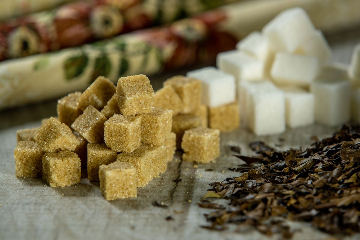 Brown and white sugar cubes beside loose tea